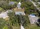 Aerial view of a property showcasing a spacious lot with lush greenery, a storage shed, and neighboring homes with pools at 1104 Larchmont Dr, Englewood, FL 34223