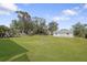 Expansive backyard with lush green grass and fire pit, ideal for outdoor enjoyment at 1104 Larchmont Dr, Englewood, FL 34223