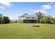 Spacious backyard with a well-maintained lawn and fire pit, perfect for gatherings at 1104 Larchmont Dr, Englewood, FL 34223