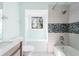 Bright bathroom with a tiled shower and white sink next to a window seat at 1104 Larchmont Dr, Englewood, FL 34223