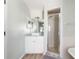 Bright bathroom featuring a single vanity, walk-in shower, and white cabinets at 1104 Larchmont Dr, Englewood, FL 34223