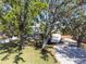 View of a two story house surrounded by large trees and a recreational vehicle parked in the driveway at 1104 Larchmont Dr, Englewood, FL 34223