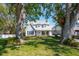 Two-story home with a lush front lawn and mature trees offering shade and privacy at 1104 Larchmont Dr, Englewood, FL 34223