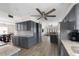Open-concept kitchen with gray cabinetry, stainless steel appliances, and seamless flow to the dining and living areas at 1104 Larchmont Dr, Englewood, FL 34223