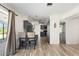 Open-concept kitchen with sleek cabinetry, stainless steel appliances, counter seating and wood-look tile flooring at 1104 Larchmont Dr, Englewood, FL 34223
