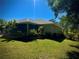 Well-maintained backyard with brick patio, lush plants, and green lawn at 13244 Doral Ave, Port Charlotte, FL 33953
