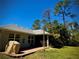 Backyard featuring lush green lawn, mature trees, and brick patio at 13244 Doral Ave, Port Charlotte, FL 33953