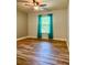 Cozy bedroom with wood floors, ceiling fan, and bright window with sheer curtains at 13244 Doral Ave, Port Charlotte, FL 33953