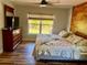 Bedroom featuring wood accent wall, wood-look flooring, and a dresser with mounted TV at 13244 Doral Ave, Port Charlotte, FL 33953