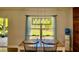 Bright dining area featuring a modern light fixture, table and chairs, and a view of the lawn through a large window at 13244 Doral Ave, Port Charlotte, FL 33953