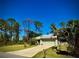 Well-maintained single-story home with a two-car garage, mature trees, and a spacious driveway at 13244 Doral Ave, Port Charlotte, FL 33953