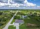 Spacious home featuring a circular driveway, attached two car garage, and landscaping in an open natural setting at 13252 Keystone Blvd, Port Charlotte, FL 33981