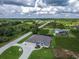 Single story home showcasing a two-car garage, turquoise entry door, manicured lawn, and circular driveway at 13252 Keystone Blvd, Port Charlotte, FL 33981