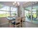 Cozy dining area with natural light and views of the lanai and a stylish chandelier above the table at 13252 Keystone Blvd, Port Charlotte, FL 33981