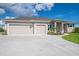 Home exterior with a three-car garage, manicured landscaping, and a modern driveway for a clean, polished look at 13252 Keystone Blvd, Port Charlotte, FL 33981