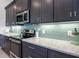 Close-up of kitchen with stainless steel appliances, light granite countertops, and backsplash tile at 13252 Keystone Blvd, Port Charlotte, FL 33981