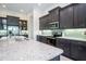Modern kitchen featuring granite countertops, dark cabinets, and stainless steel appliances with bar stool seating at 13252 Keystone Blvd, Port Charlotte, FL 33981
