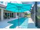 Sparkling pool featuring a sun umbrella, enclosed within a screened-in lanai, surrounded by lush landscaping at 13252 Keystone Blvd, Port Charlotte, FL 33981