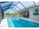 An enclosed swimming pool with an attached covered patio, and complete with outdoor seating under an umbrella at 13252 Keystone Blvd, Port Charlotte, FL 33981