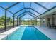 An enclosed swimming pool with an attached covered patio, and complete with outdoor seating under an umbrella at 13252 Keystone Blvd, Port Charlotte, FL 33981