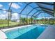 An enclosed swimming pool with an attached covered patio, and complete with outdoor seating under an umbrella at 13252 Keystone Blvd, Port Charlotte, FL 33981