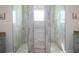 Stylish walk-in shower featuring natural stone tile, dual sinks, and plenty of natural light at 13252 Keystone Blvd, Port Charlotte, FL 33981