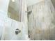 Close-up of a stylishly tiled walk-in shower featuring natural stone tile and modern fixtures at 13252 Keystone Blvd, Port Charlotte, FL 33981