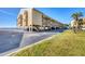 The exterior view of the building shows covered parking and a glimpse of the water in the background at 14459 River Beach Dr # 122, Port Charlotte, FL 33953