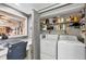 Efficient laundry area with modern washer, dryer, workspace, and ample shelving for storage at 14459 River Beach Dr # 122, Port Charlotte, FL 33953