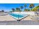 Community pool surrounded by palm trees and lounge chairs offering a refreshing outdoor experience at 14459 River Beach Dr # 122, Port Charlotte, FL 33953