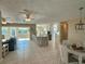 Bright, open-concept living area with tile floors, ceiling fan, and seamless flow into the kitchen and dining area at 1490 Janet Pl, Englewood, FL 34223