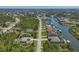 Wide aerial shot of a gray-roofed single-Gathering home surrounded by verdant trees, canals, and neighboring houses at 15613 Alsask Cir, Port Charlotte, FL 33981
