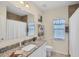 Well-lit bathroom featuring a granite vanity countertop, a tiled shower, and a window at 15613 Alsask Cir, Port Charlotte, FL 33981