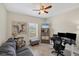 Comfortable room setup as an office with a sofa, ceiling fan, and neutral decor at 15613 Alsask Cir, Port Charlotte, FL 33981