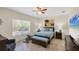 Comfortable bedroom with a queen bed, ceiling fan, and natural light from a large window at 15613 Alsask Cir, Port Charlotte, FL 33981
