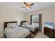 Shared bedroom with two twin beds, ceiling fan, and natural light from a window at 15613 Alsask Cir, Port Charlotte, FL 33981