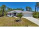 Charming home featuring a gray roof, complemented by a well-maintained lawn and a spacious two-car garage at 15613 Alsask Cir, Port Charlotte, FL 33981