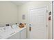 Functional laundry area featuring a washer, dryer, and access door at 15613 Alsask Cir, Port Charlotte, FL 33981