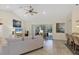 Bright living room with tile floors, fan, and a view of the backyard, connected to bar seating and kitchen at 15613 Alsask Cir, Port Charlotte, FL 33981