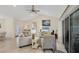 Comfortable living room with tile, a fan, sliding glass doors, and a view of the entrance and eat-in-kitchen at 15613 Alsask Cir, Port Charlotte, FL 33981