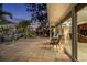 Beautiful home's back patio with tile flooring and views of the lush backyard landscaping and waterway at dusk at 1648 Shelburne Ln, Sarasota, FL 34231