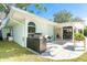 Backyard patio with outdoor kitchen, grill, and covered area adjacent to the home's open sliding glass doors at 1648 Shelburne Ln, Sarasota, FL 34231