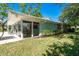 Exterior view with lush lawn and covered patio area, offering a serene outdoor space at 1648 Shelburne Ln, Sarasota, FL 34231