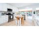 Well-lit kitchen with stainless appliances, tile flooring, white cabinets, and backyard view at 1648 Shelburne Ln, Sarasota, FL 34231