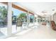 Bright sunroom with floor to ceiling windows overlooking a tropical backyard and water at 1648 Shelburne Ln, Sarasota, FL 34231