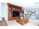 Large living room with built-in shelving, travertine floors, and view to front and rear at 1648 Shelburne Ln, Sarasota, FL 34231