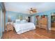 Relaxing main bedroom with blue walls, wood floors, ceiling fan and ensuite bathroom at 1648 Shelburne Ln, Sarasota, FL 34231