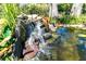 Backyard waterfall detail with tropical landscaping at 1648 Shelburne Ln, Sarasota, FL 34231