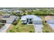 Stunning aerial view of a white waterfront home with a metal roof, lush landscaping, and a paver driveway at 18610 Ayrshire, Port Charlotte, FL 33981