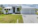 Beautiful one-story home with modern white exterior, black window accents, and well-manicured lawn at 18610 Ayrshire, Port Charlotte, FL 33981